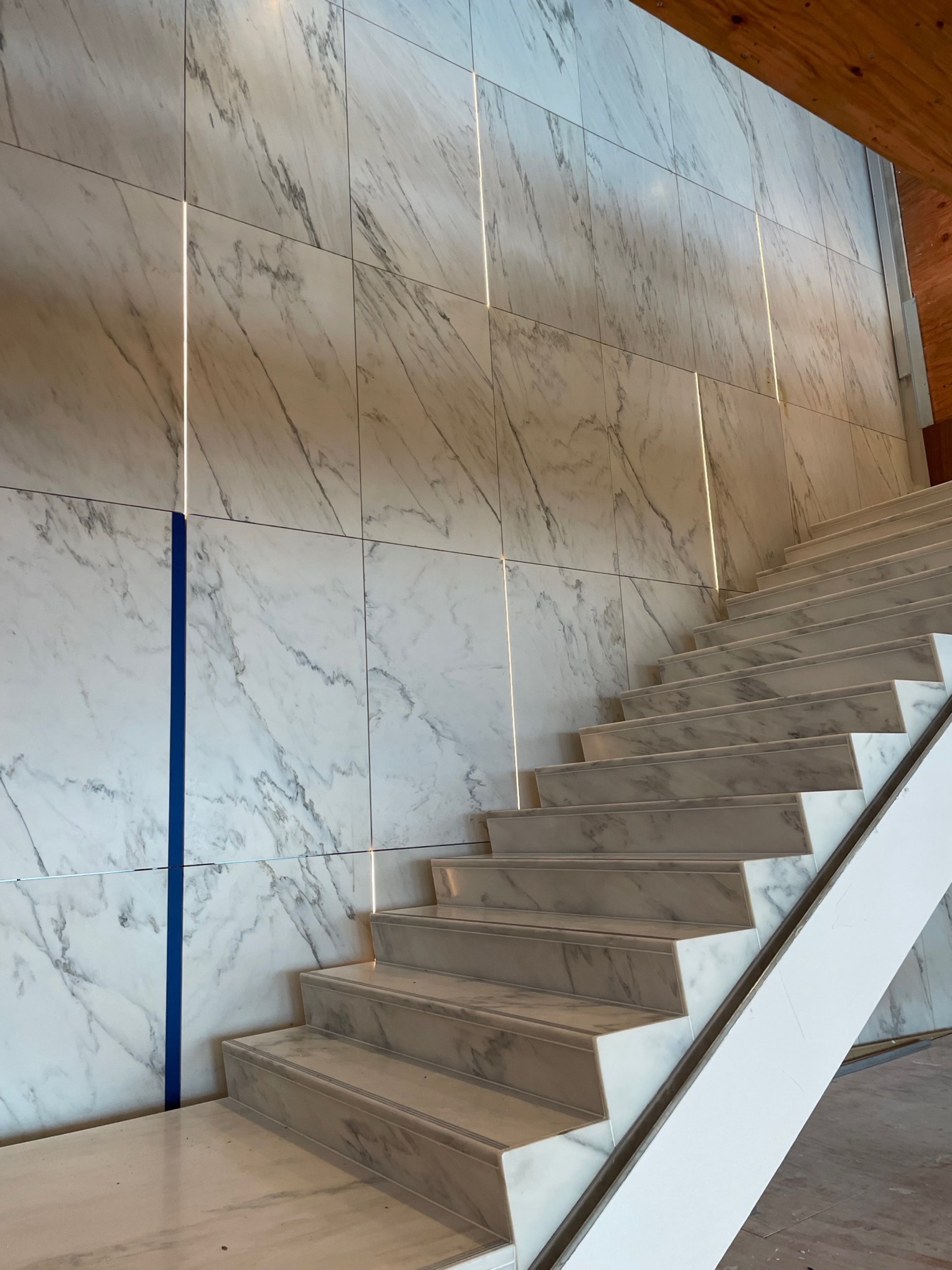 Installed Alabama White wall panels beside matching marble stairs on the executive floor at FIS Headquarters