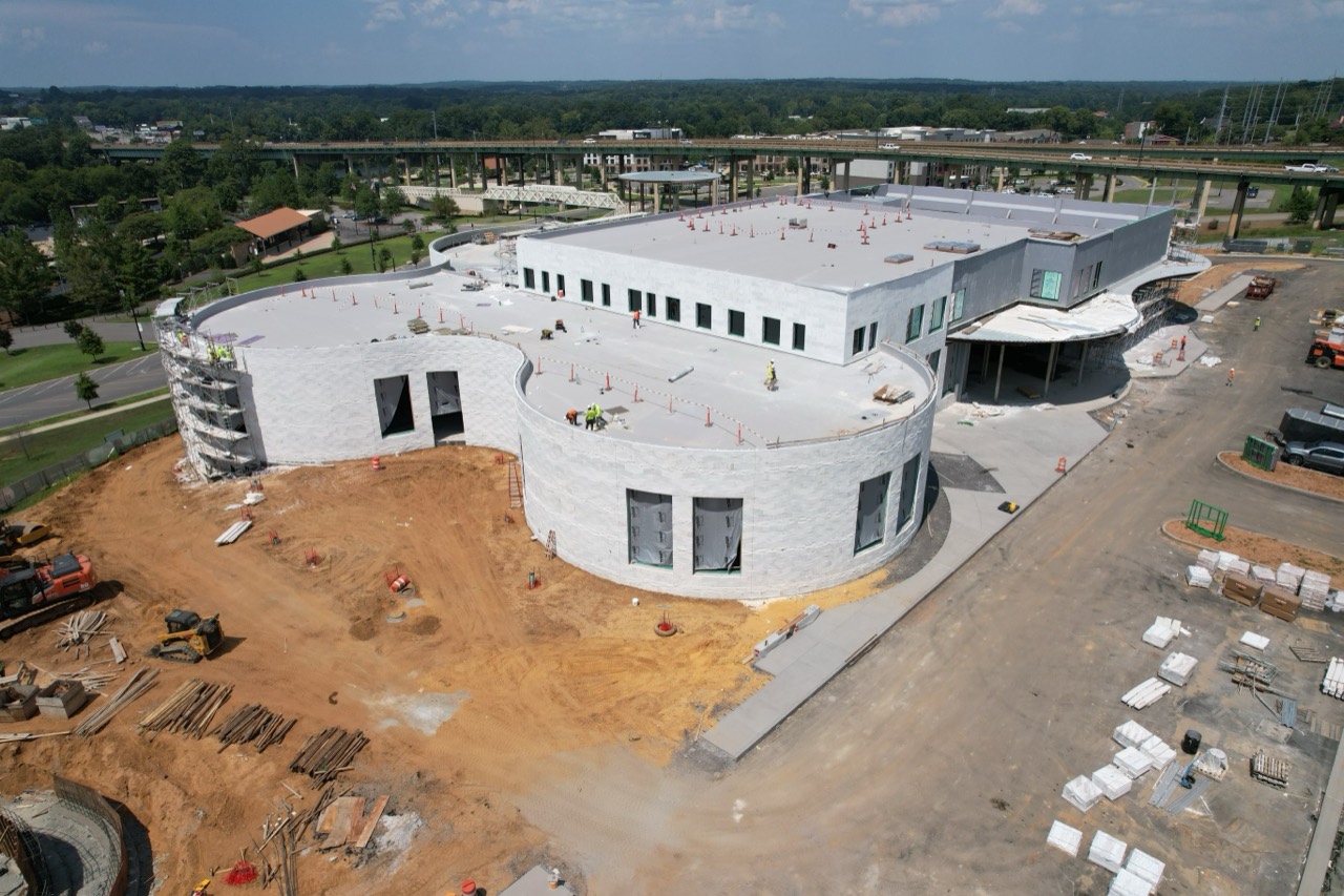 Wide aerial view of the Saban Center under construction with Alabama White marble across its curved exterior